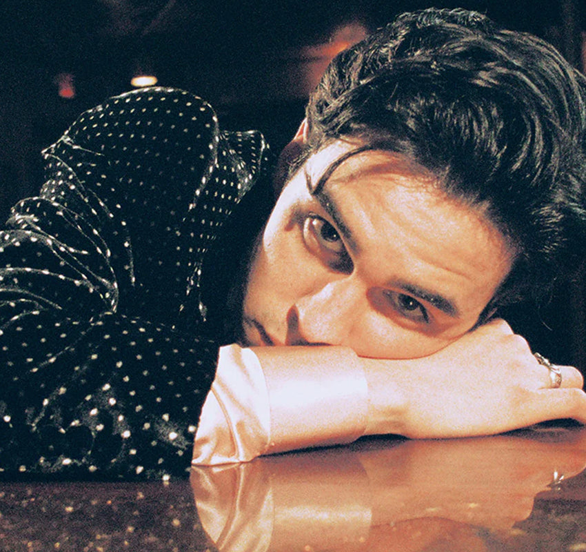 Person leaning over a bar with a dark, moody atmosphere